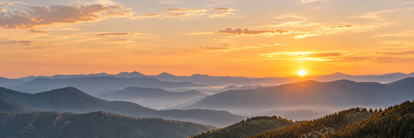 Golden sunrise over misty mountain ridges